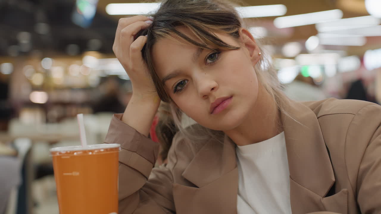 생각에 잠긴 젊은 소녀, 캐주얼한 식사 분위기에 몰두한 사춘기 소녀, 점심시간에 푸드코트에 앉아 곰곰이 생각하는 듯 보이는 어린 소녀