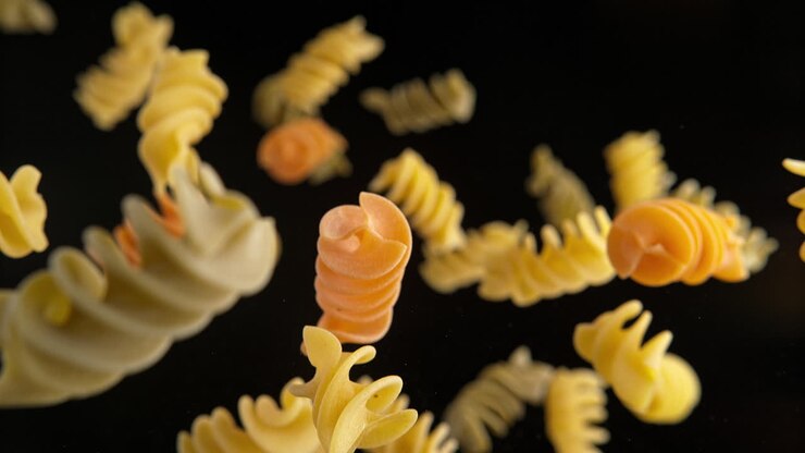 Colorful Fusilli Pasta Flying On The Black Background In Slow Motion And Macro