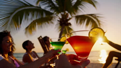 friends enjoying cocktails at sunset on the beach