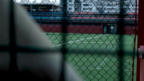 tracking glimpse of forbidden soccer football field hidden behind chain link fence