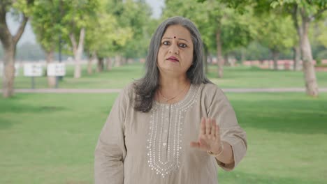 Stressed-Indian-old-woman-shouting-at-someone-in-park