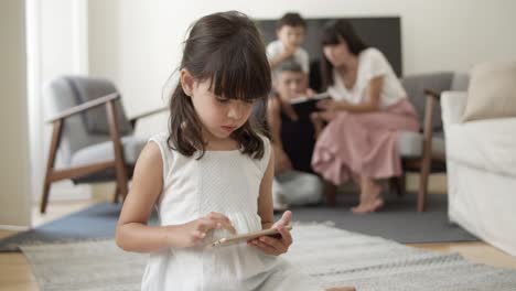 young girl smiling at camera, then using smartphone