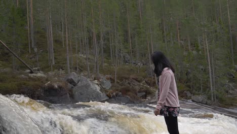 girl standing on the side of a crazy river