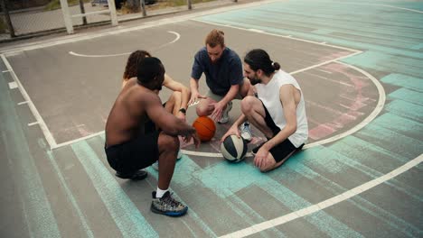 equipo de baloncesto multirracial habla de su estrategia en el campo de baloncesto antes de que comience el juego