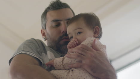 amoroso papá acunando a su linda niña en sus brazos en casa 1