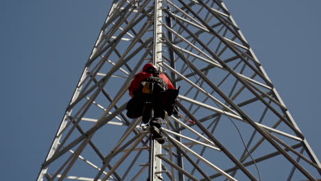 Mann-Klettert-Zur-Wartung-Auf-Den-Hochgelegenen-Strommast