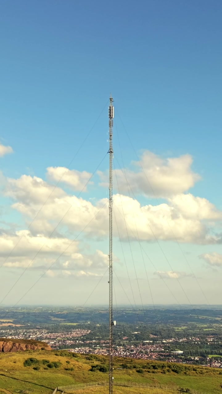 Video aereo ravvicinato della torre di trasmissione televisiva di Black Mountain a West Belfast, Irlanda del Nord, in una luminosa sera d'estate. Prodotto a 60FPS, rapporto 1080x1920 per social media e con colore Rec709
