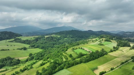 european hillside, fertile rural land and mountains in background landscape panorama