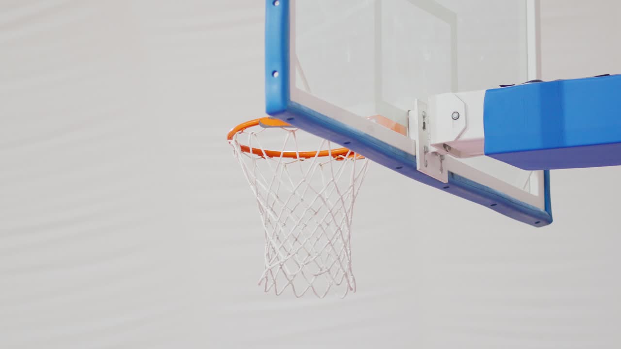 Basketball in slow motion going through the hoop with a clean swish shot