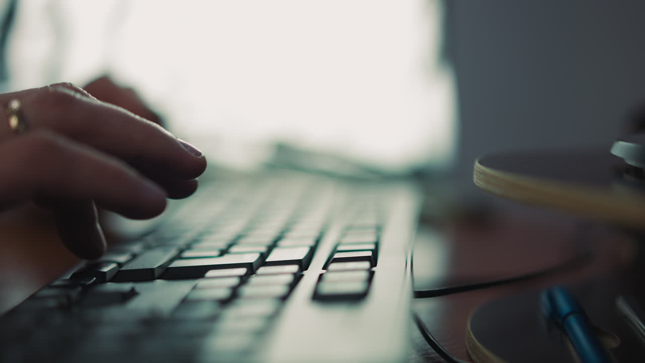 Person hands type on computer keyboard sitting at table