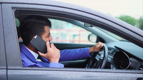 man driving a car and talking on phone