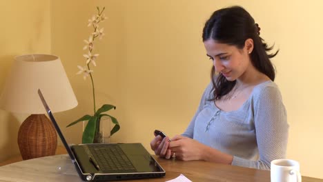 Positive-woman-at-computer-sending-a-text-message