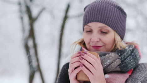 Eine-Frau-Wärmt-Sich-Mit-Einem-Heißen-Ay-In-Einem-Winterpark-Auf