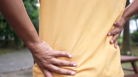 young man in blue shirt suffering back pain
