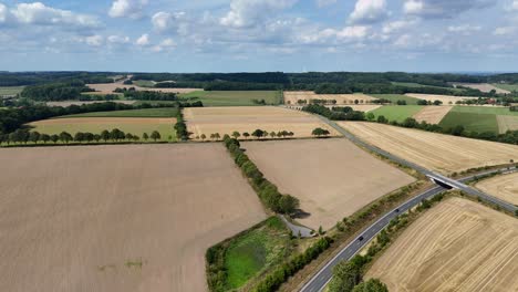 american countryside with farm fields and cropland. aerial wide shot. cropland and farmland in quiet rural suburb of town. interstate highway in usa. sunny summer day in des moines, iowa