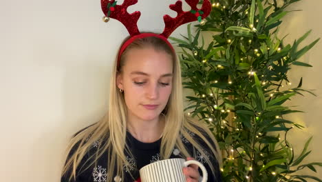 young woman joining christmas video call waving and talking directly into camera