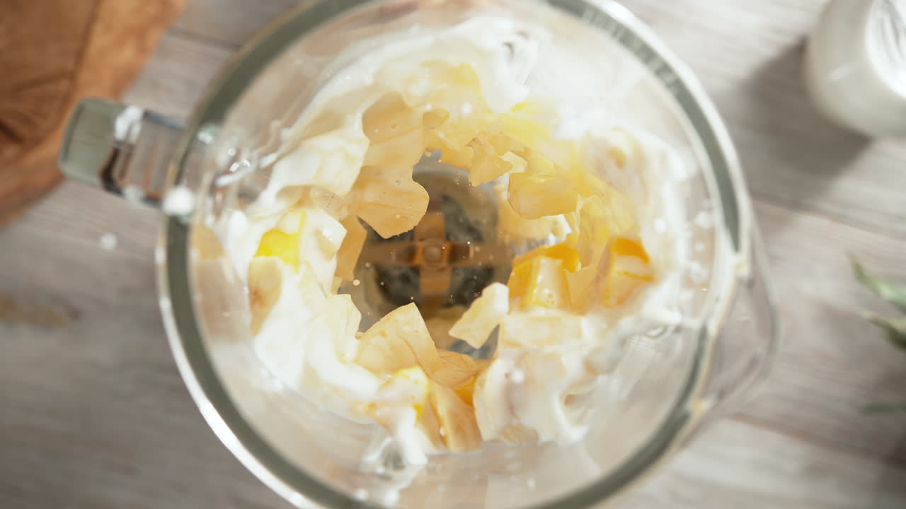 파인애플, 망고, 바나나 스무디가 유리 블렌더에 여 느린 동작으로, 위쪽 시각, 장치 내부