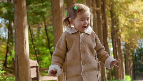 playful little girl jumps in autumn park