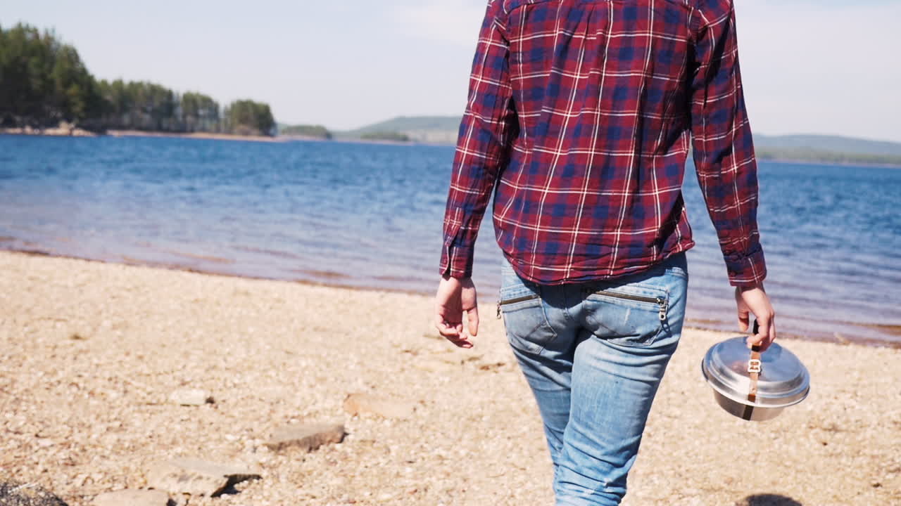 호수에서 화창한 날 trangia 휴대용 난로와 함께 해변에서 멈추는 스웨덴 소녀