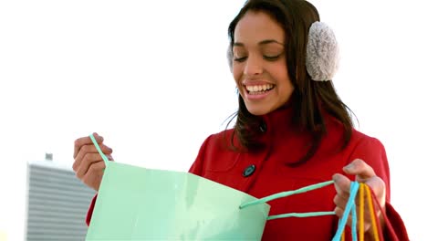 chica sonriente mirando en una bolsa de compras bonita