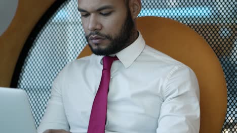 Thoughtful-businessman-using-laptop