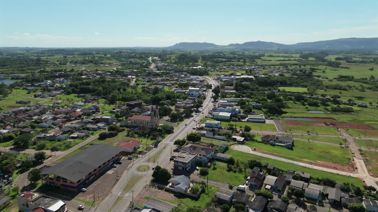 Glorinha appears in a wide aerial established shot with the main avenue, town center and surrounding countryside in Rio Grande do Sul, Brazil