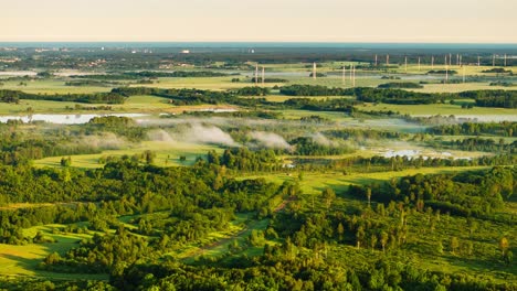 perfect landscape timelapse - drifting fog and wind turbines at sunrise, latvia