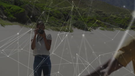 Person taking photo on beach with network connections animation overlay