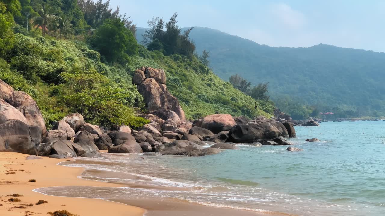 paisaje de playa de montaña con árboles verdes exuberantes, pequeñas olas que se estrellan, costa de arena dorada