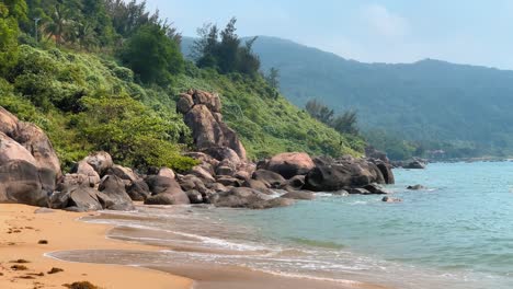 Bergstrandlandschaft-Mit-üppigen-Grünen-Bäumen,-Kleinen-Wellen-Und-Goldenem-Sandstrand