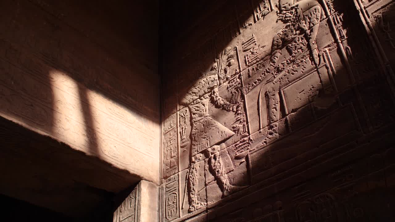 Sunrays hitting the hieroglyphs on the walls inside the temple of Philae, Aswan, Egypt.