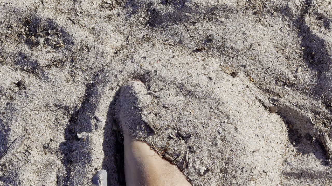 Close up of a man's foot playing in the sand at the beach