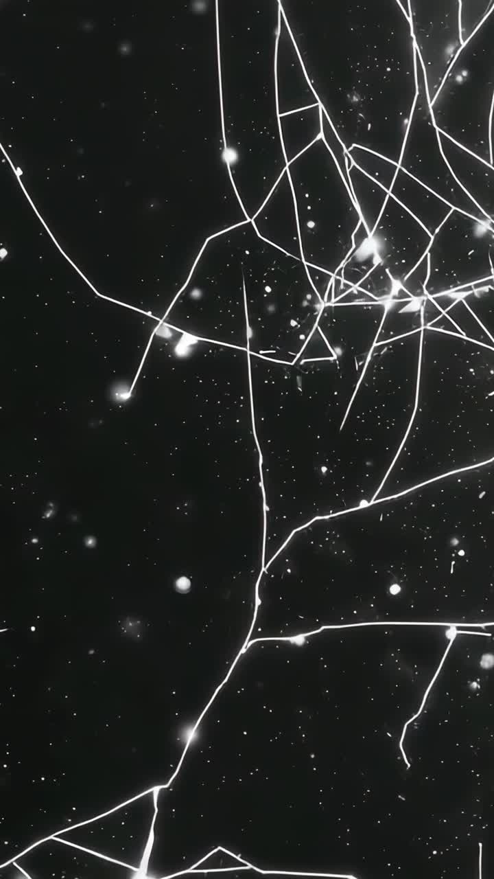 Vertical video: Expanding crack network across studio glass panel as frames progress, nodes specks