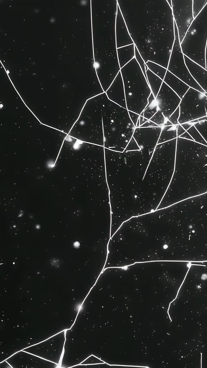 Vertical video: Expanding crack network across studio glass panel as frames progress, nodes specks
