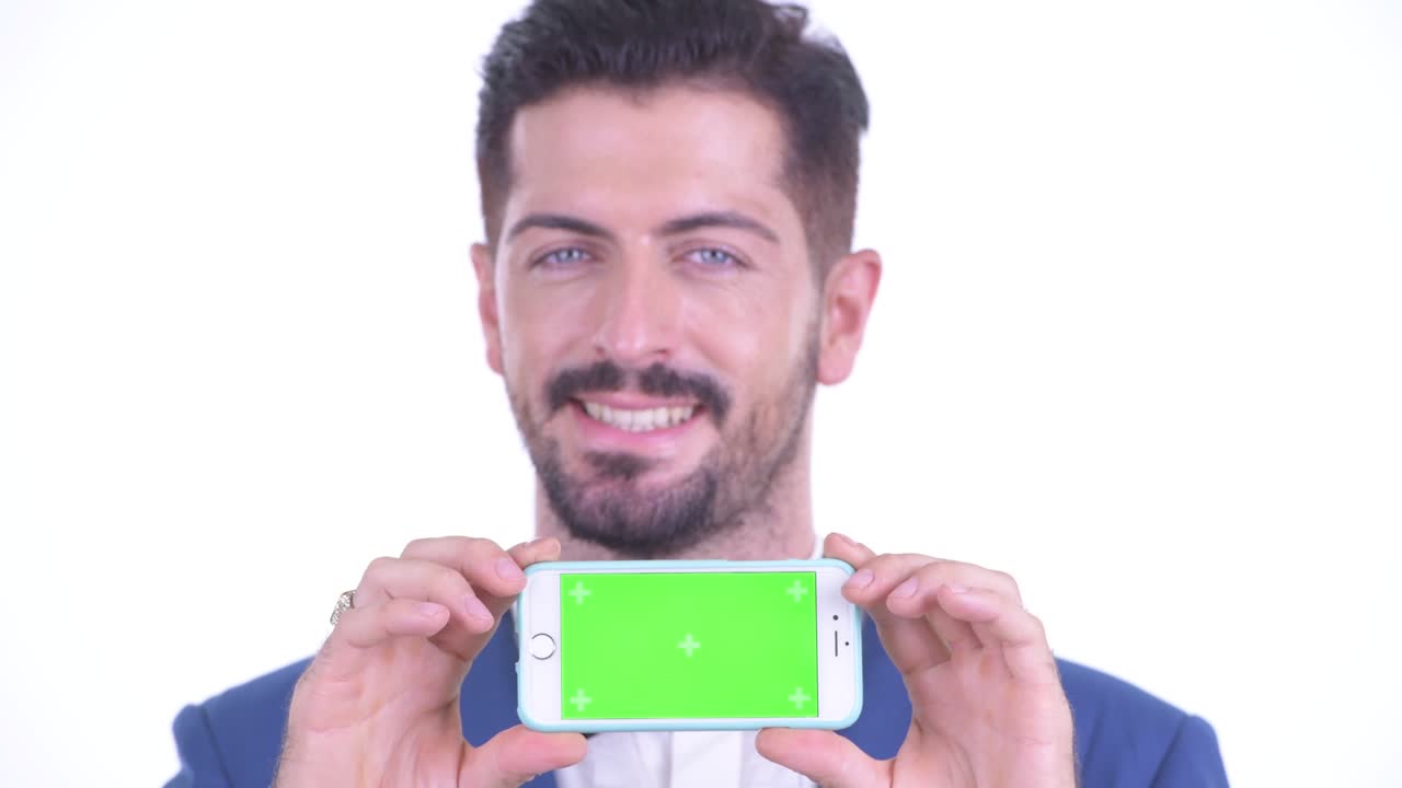 Portrait of businessman smiling and showing mobile phone with copy space
