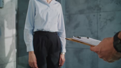 woman receiving and signing for a package delivery