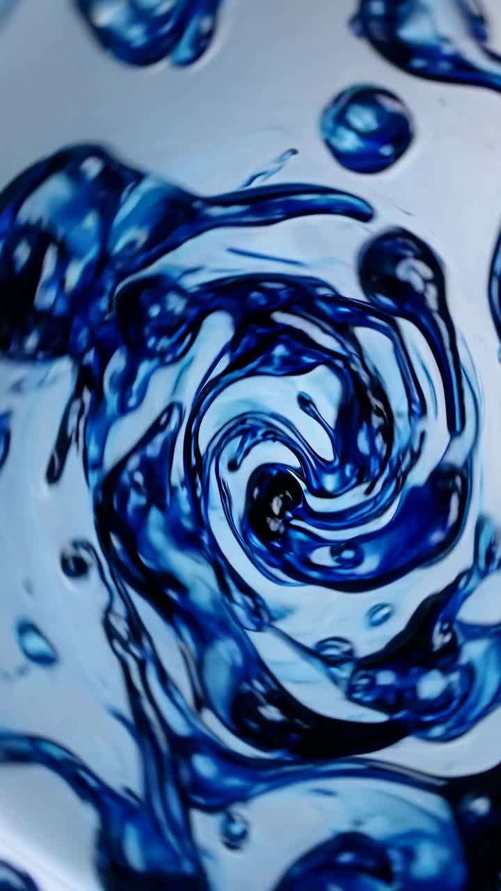Vídeo abstrato em close-up de padrões de líquido azul turbilhonante, capturado em ângulo superior.
