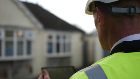 an official building inspector architect inspecting a building house using a tablet