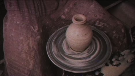 the potter makes a jug of clay. vintage effect. a man makes a vase on a potter's wheel