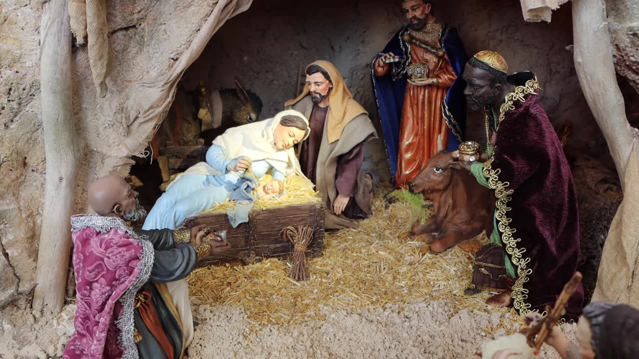 a beautiful handmade nativity with lights and figures of shepherds, joseph, jesus and mary. The baby Jesus is for this Christmas