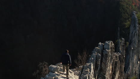 man walking on steep rock formation, seneca rocks, west virginia usa