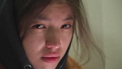 걱정스러운 표정을 가진 어린 소녀의 얼굴의 클로즈업, 그녀의 눈은 깊은 우려 또는 숙고를 반영하여 아래로 던집니다. 은 그녀의 감정의 미묘한 세부 사항을 포착합니다.