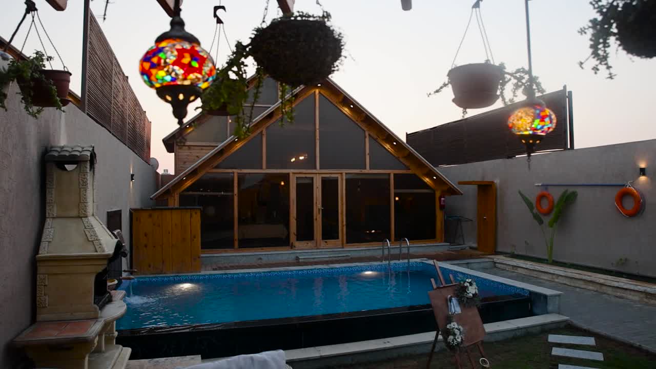 Lights hang in backyard with pool of beautiful luxurious house with big windows