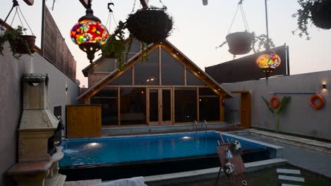 lights hang in backyard with pool of beautiful luxurious house with big windows