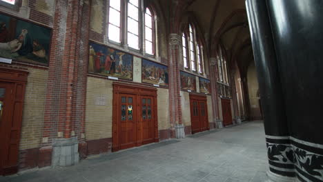 wooden doors with paintings above inside the brick building of gouwekerk church in gouda, netherlands