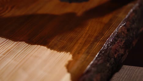 applying wood stain to a wooden table top