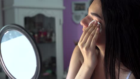 la chica se quita el maquillaje.