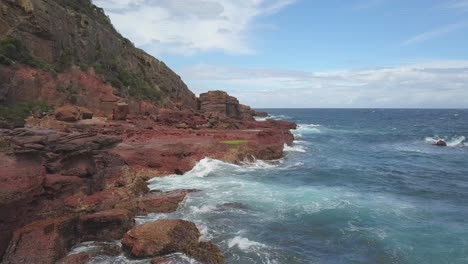 red rocks and ocean waves crashing on the coastline