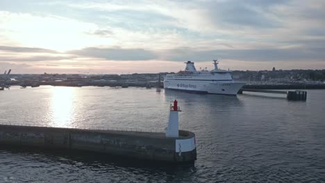 brittany ferries in saint-malo port at sunset with môle des noires lighthouse in foreground, france