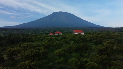 flying over a tropical village with mount agung background, aerial